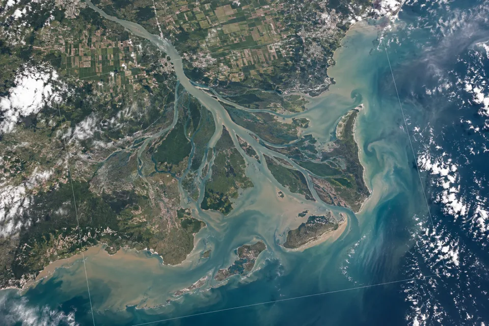 Vista orbital de un delta fluvial, áreas agrícolas y ecosistemas costeros.